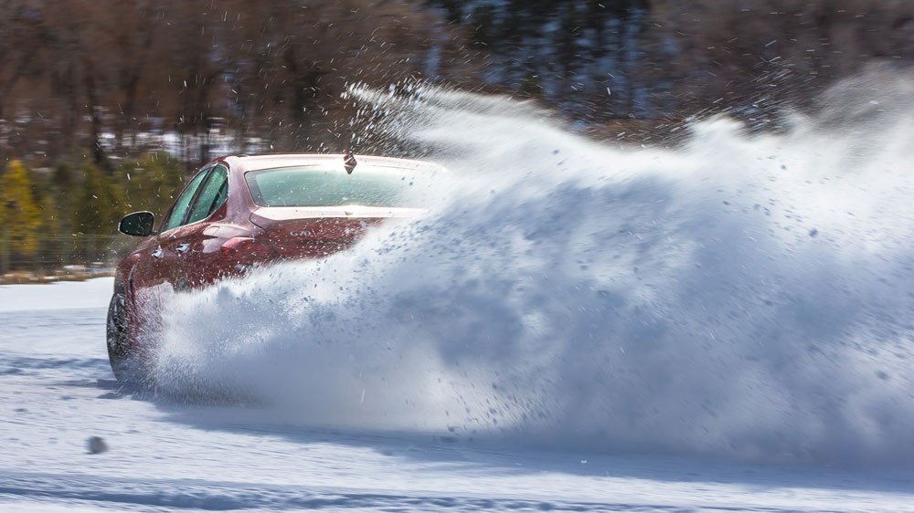 The Genesis G70 sedan being driven in snow.