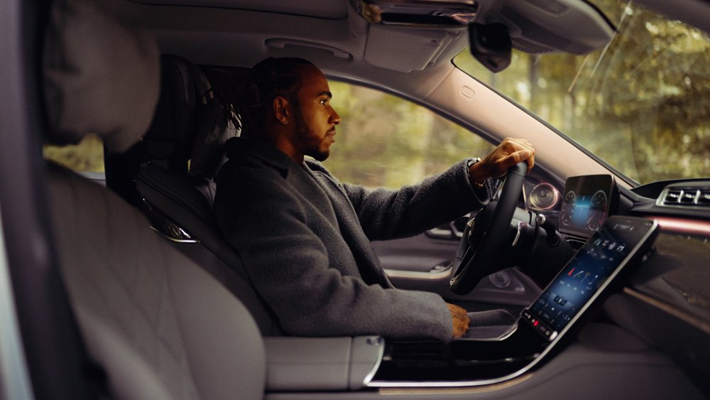 Formula 1 champion Lewis Hamilton sits in the driver's seat of a new Mercedes-Benz S-Class.