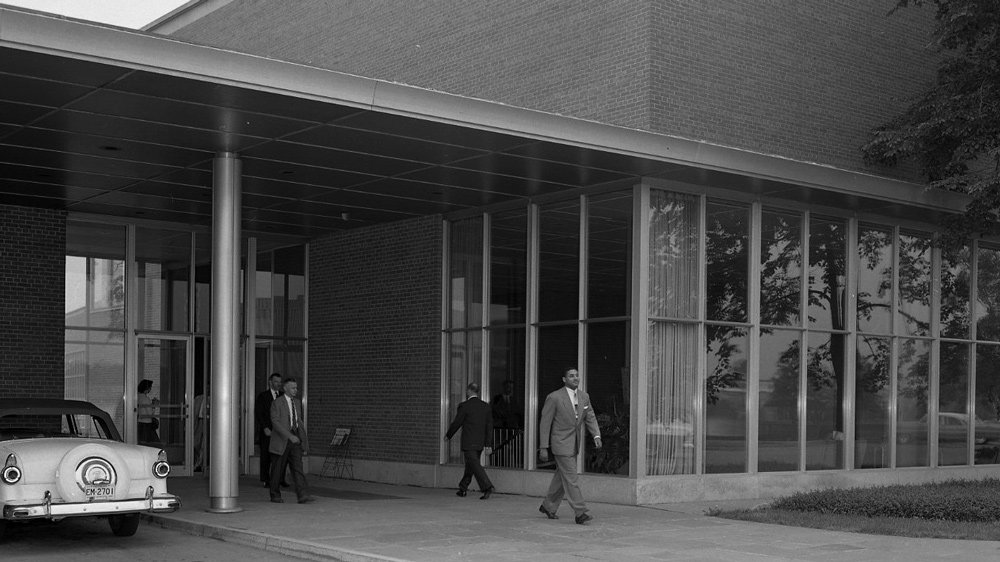 Automotive designer McKinley Thompson (foreground) walking in front of the Ford Product Development Center in Dearborn, Mich.