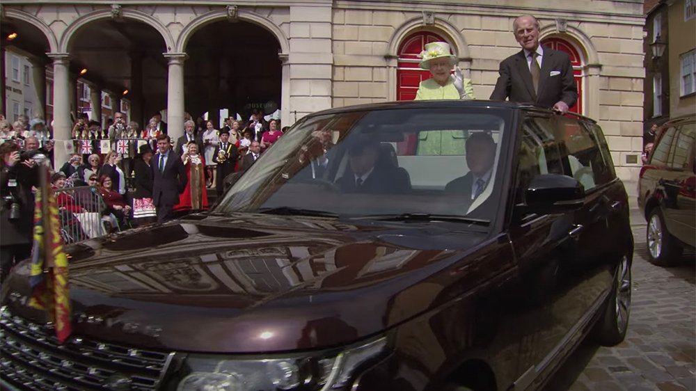 Queen Elizabeth and Prince Philip ride in a convertible Range Rover on the Queen's 90th birthday