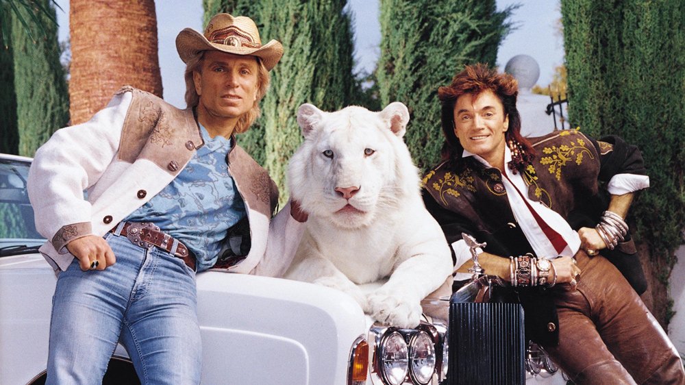 The magicians Siegfried & Roy pose with white tigers next to Roy horn's 1994 Rolls-Royce Corniche.