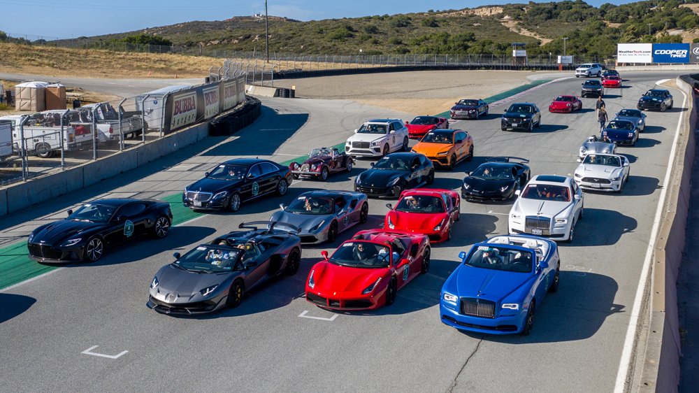 Cars in Robb Report's California Coastal road rally lined up on the track at WeatherTech Raceway Laguna Seca.