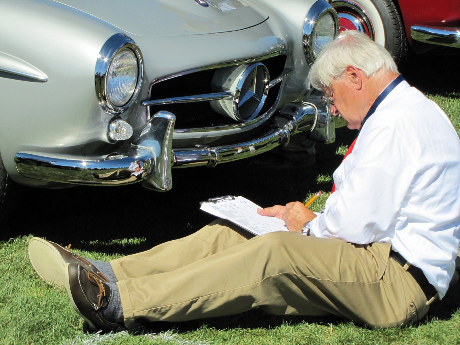 A concours Judge inspects a Mercedes-Benz 190SL at Legends of the Autobahn 2015 event | Bob Golfen photo
