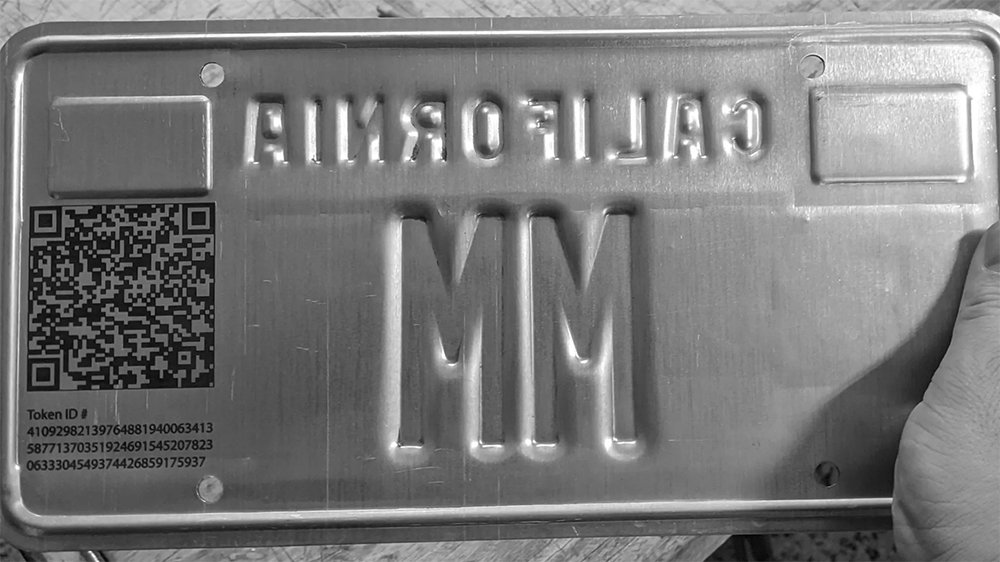 The NFT's QR code and Token ID are inscribed on the back of the 