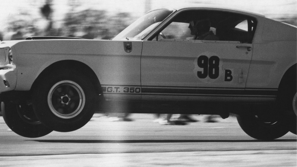 Racer Ken Miles catching air in a 1965 Shelby GT350R prototype.
