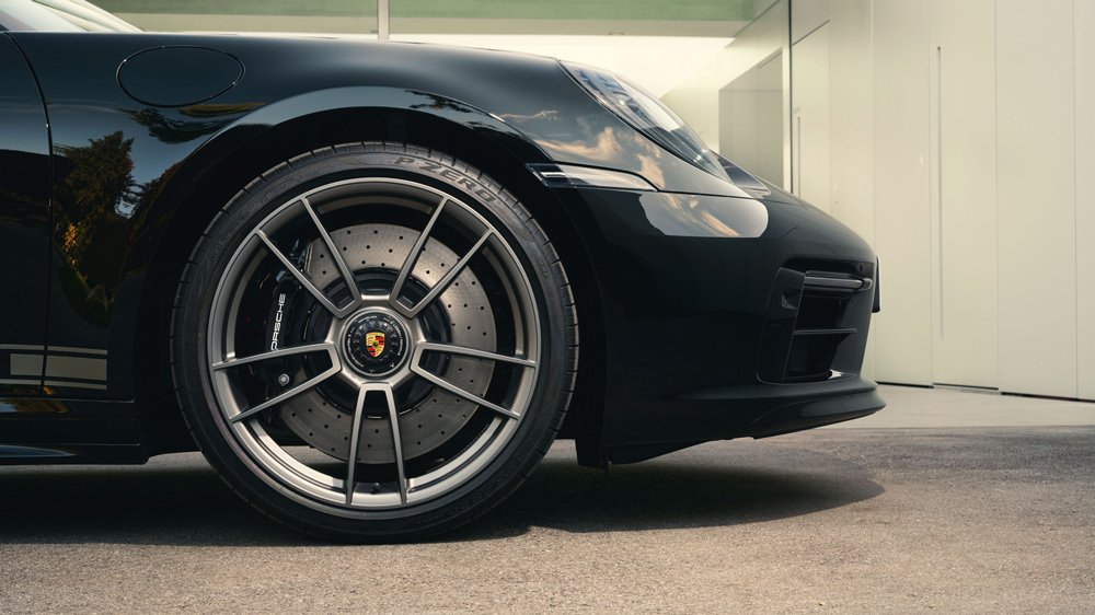 The right front wheel of a 911 Porsche Design 50th Anniversary Edition sports car.