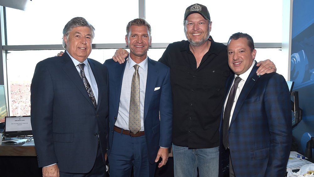 From right: Tony Stewart poses with musician Blake Shelton along with Clint Boyer and Mike Joy of Fox Sports in the broadcast booth.