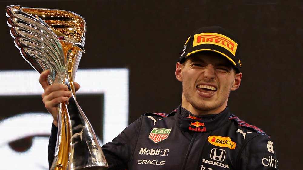 Max Verstappen hoists his trophy after winning the 2021 Formula 1 Drivers' Championship.