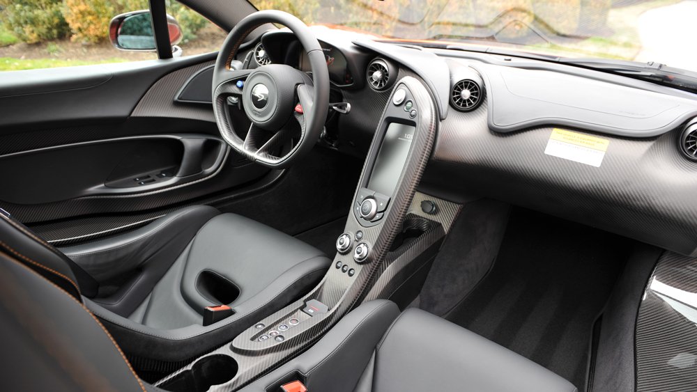 The interior of a 2015 McLaren P1 supercar in Volcano Orange.