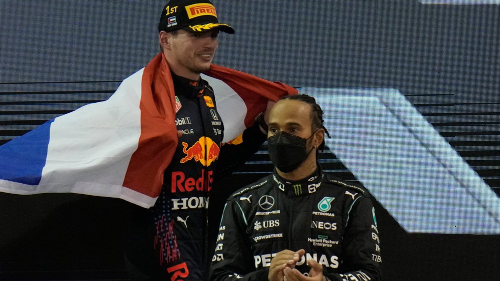 Lewis Hamilton and Max Verstappen on podium after the latter was named Formula 1's 2021 Drivers' Champion.