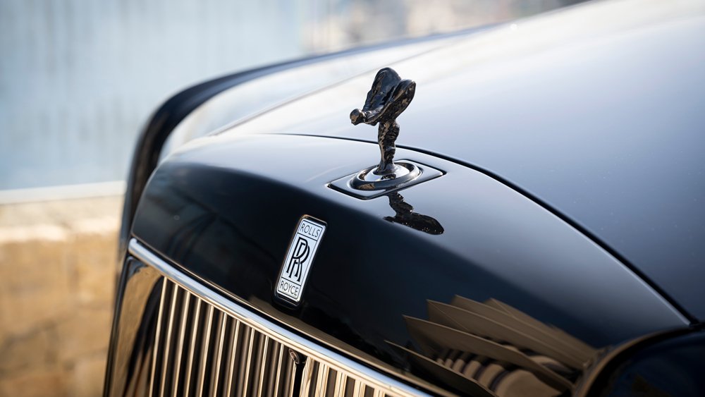 A close-up of the Spirit of Ecstasy hood ornament on a Rolls-Royce Phantom Series II sedan.