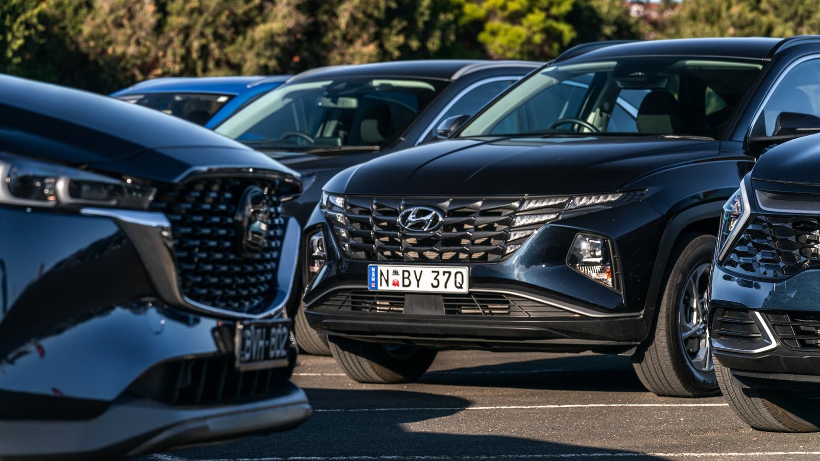 A blue 2022 Hyundai Tucson amongst other medium SUVs