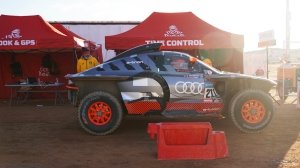 An Audi RS Q e-tron is prepped for an early-morning start during the 2023 Dakar Rally.