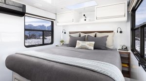 The primary bedroom on Living Vehicle HD with an overhead skylight and two large windows for scenic views. 
