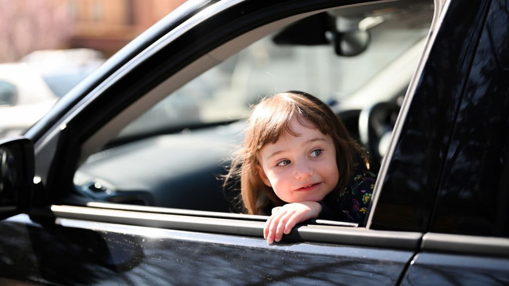 Child sitting in front seat of car