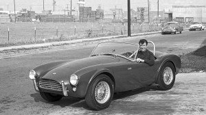 Circa 1962, Carroll Shelby sits behind the wheel of a Shelby-Cobra 260.