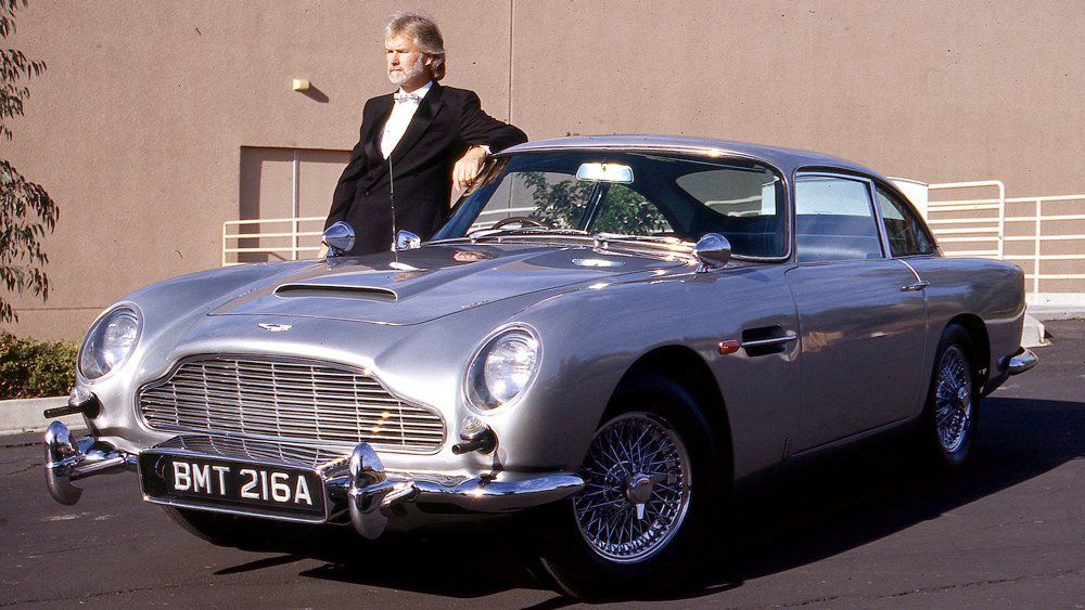 Writer Howard Walker standing by the original Aston Martin DB5 driven by actor Sean Connery in the James Bond film