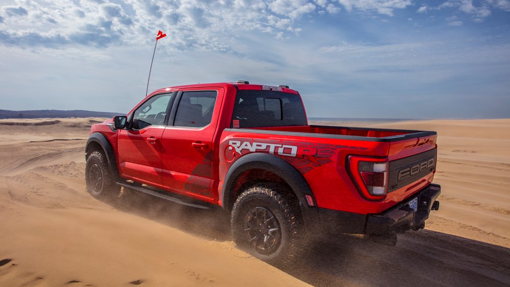 The 2023 Ford F-150 Raptor R driving on sand dunes.