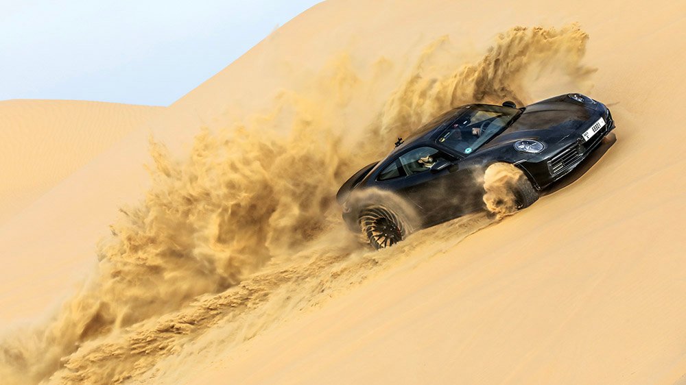 The Porsche 911 Dakar prototype rides a sand dune