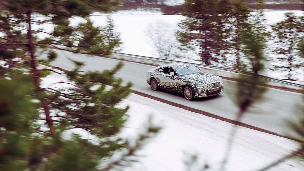 The Rolls-Royce Spectre drives through a snowy landscape
