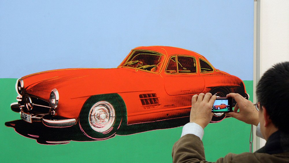 A visitor takes a photo of Andy Warhol's  Mercedes-Benz 300 SL Coupe (1954) at the Albertina museum, in Vienna, Austria, Thursday, Jan. 21, 2010. Under the title 