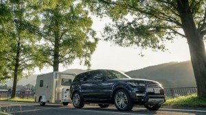 The X-Cabin300 travel trailer towed by a Range Rover Sport